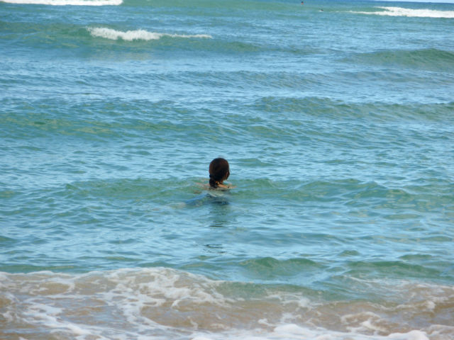 ハワイ　ワイキキの海で泳ぐ妻